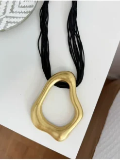 Collar cordón piel negra figura dorada